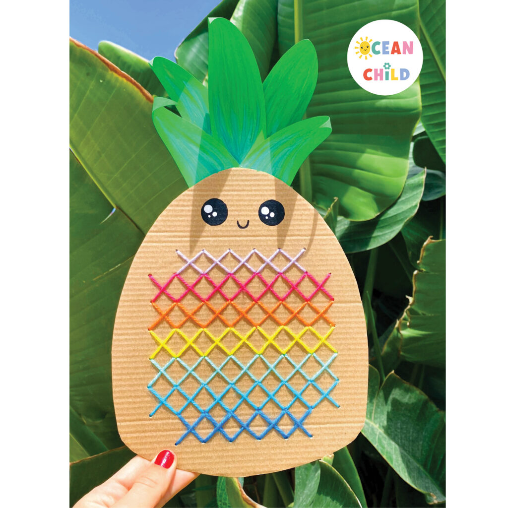 Completed pineapple cross-stitch craft for kids made with yarn and cardboard